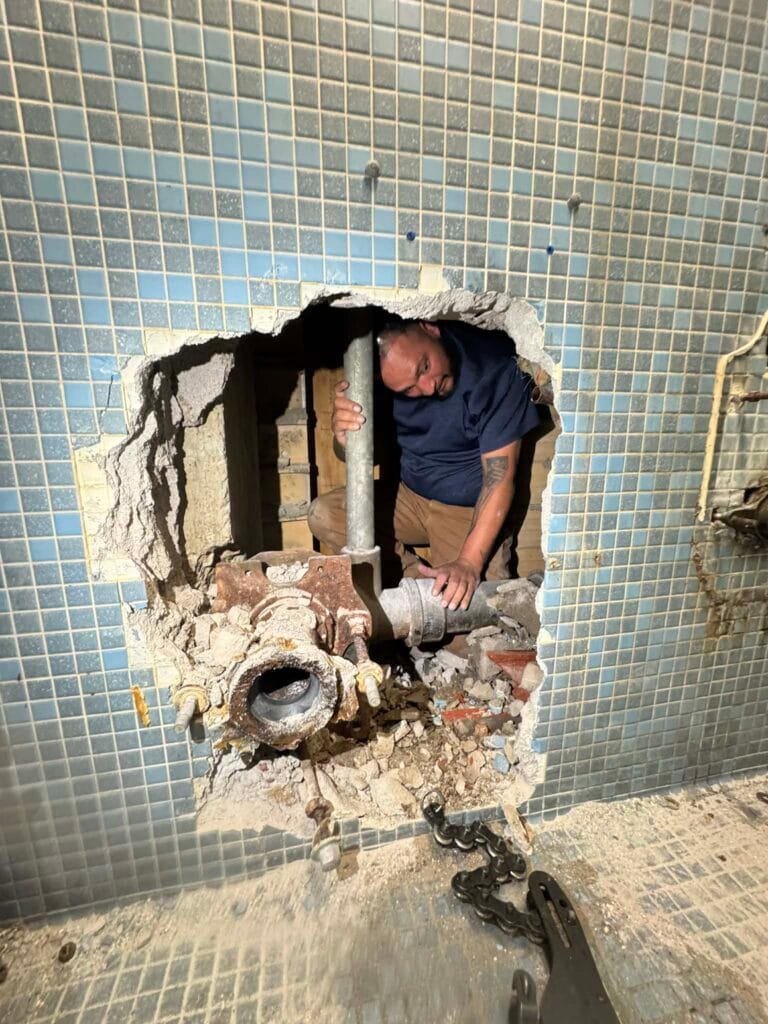 Gallery | Imperial Plumbing LLC Plumber repairing pipes through an opened tile wall